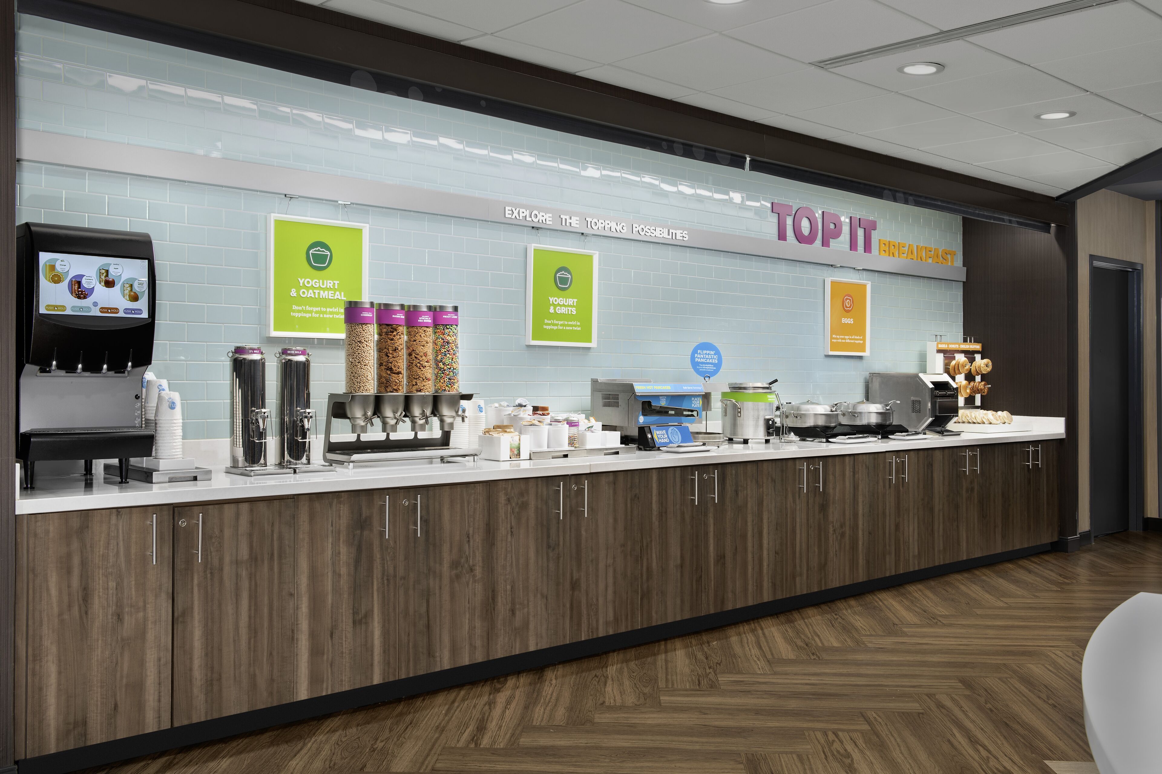 A breakfast area with a yogurt and oatmeal dispenser, a coffee machine, and a sign for Topit breakfast.