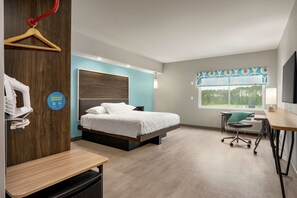 A modern hotel room with a bed, desk, chair, and a large window. - Tru by Hilton Florence I-95 (Florence)
