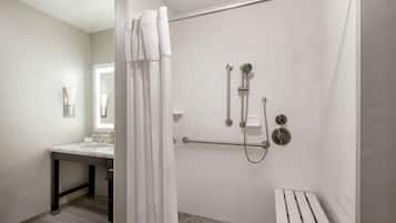 A modern bathroom with a shower, a vanity, and a toilet.