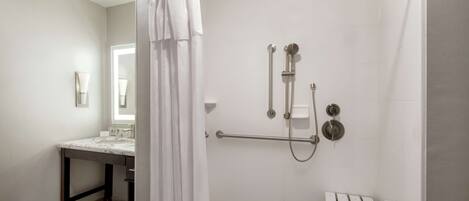 Une salle de bain moderne équipée d’une douche, d’un meuble-lavabo et de toilettes.