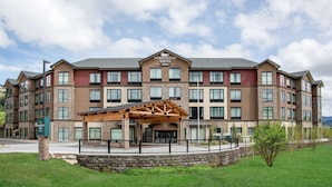 A multi-story hotel with a prominent entrance, a covered outdoor area, and a stone facade.