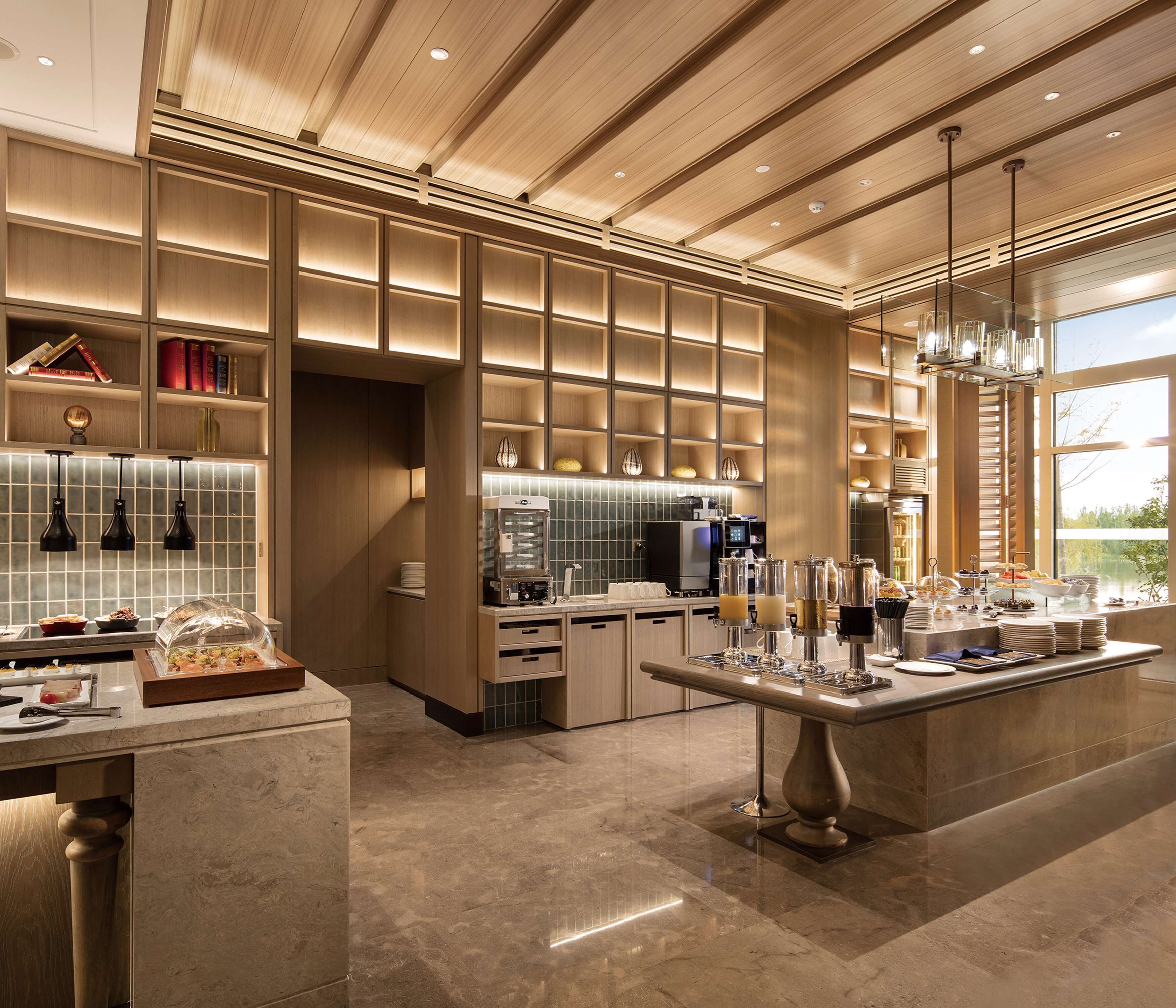 A modern kitchen with a marble countertop, built-in appliances, and a large island.