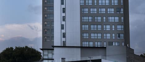 Un hotel Hampton Inn con un diseño moderno, que presenta un letrero llamativo y múltiples ventanas.