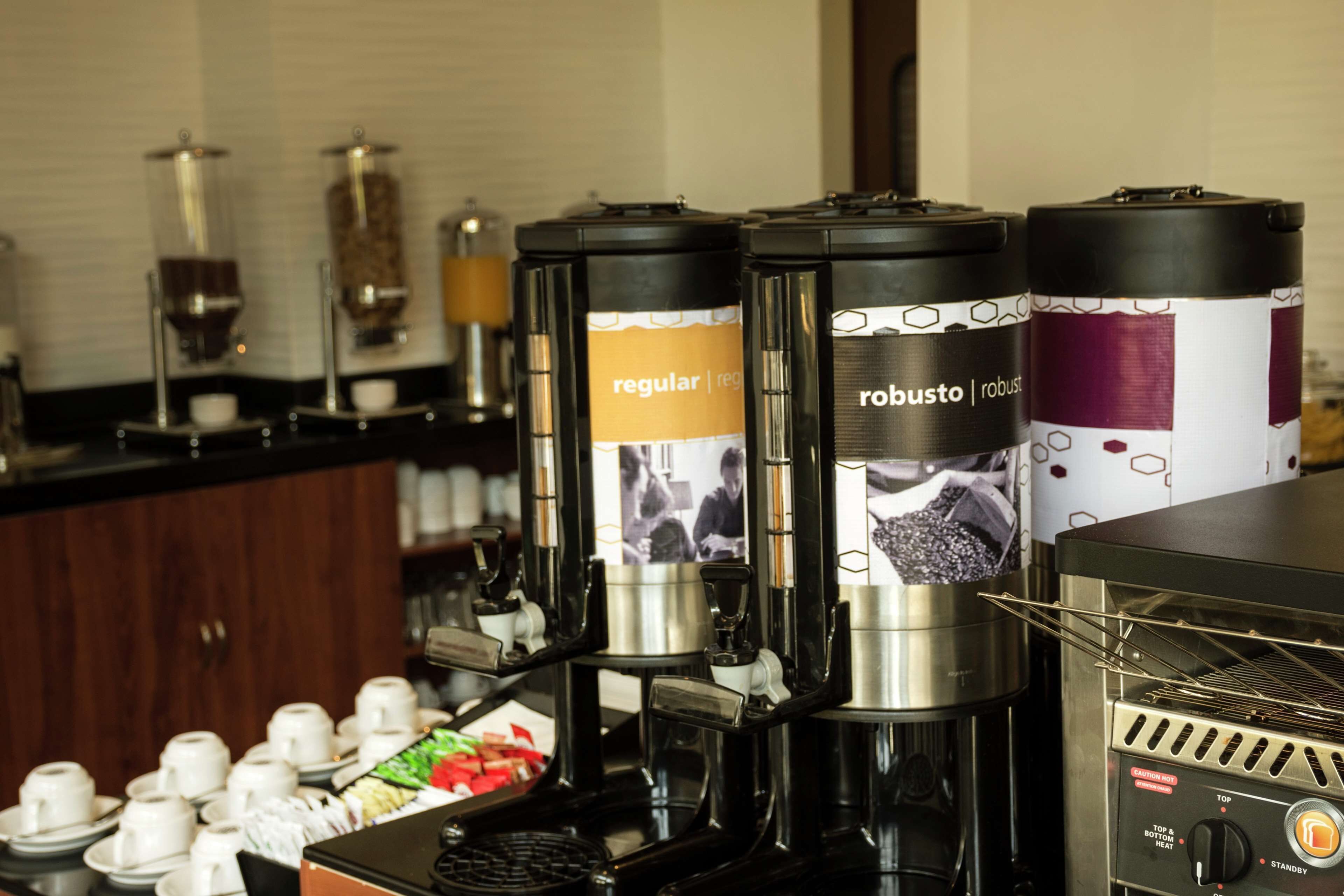 A coffee station with multiple coffee dispensers labeled 'regular' and 'robusto'.