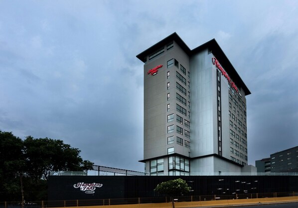 Um edifício de hotel moderno e imponente com uma placa de destaque com a inscrição "Hampton Inn".