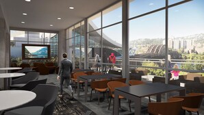 A modern indoor space with large windows offering a view of a bridge and cityscape. - AC Hotel Pittsburgh Downtown (Pittsburgh)