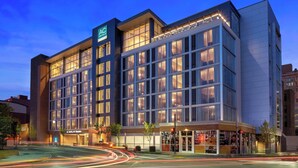 A modern hotel with a prominent 'AC' sign, large windows, and a well-lit entrance. - AC Hotel Pittsburgh Downtown (Pittsburgh)