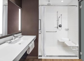 A modern bathroom with a white vanity, a glass shower enclosure, and a large mirror. - AC Hotel Pittsburgh Downtown (Pittsburgh)