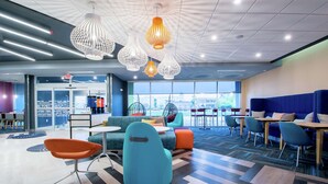 A modern interior with seating areas, a coffee bar, and large windows offering a view.