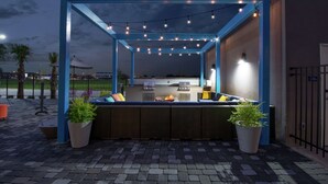 An outdoor patio area with a blue structure, seating, and string lights.