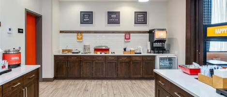 A modern kitchen with wooden cabinets, a coffee machine, and a breakfast bar.
