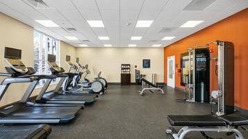 A gym with treadmills, elliptical machines, and weightlifting equipment.