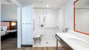 Een moderne badkamer met douche, toilet en wastafel.
