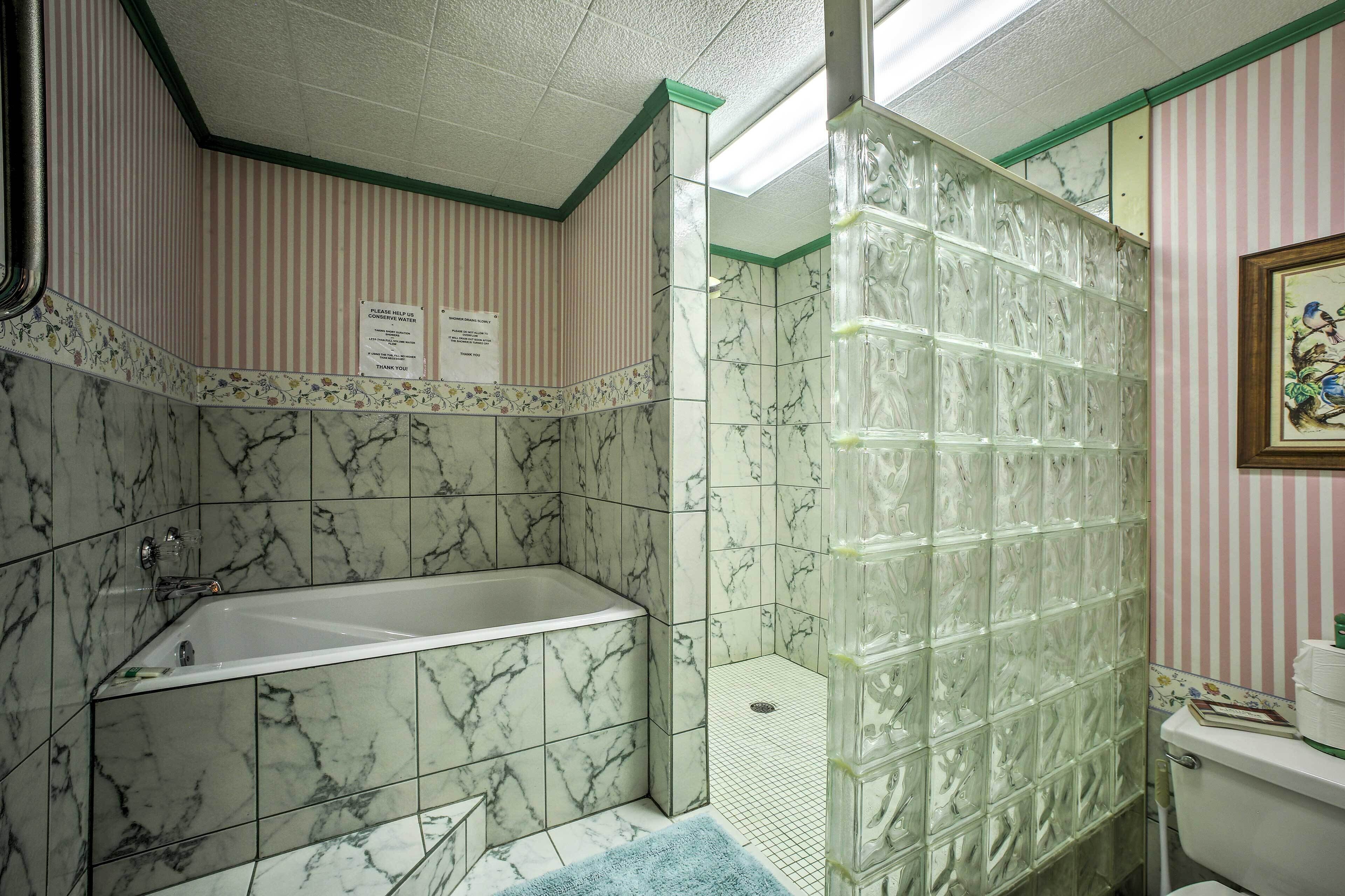 A bathroom with a bathtub, a shower enclosure, and a toilet.