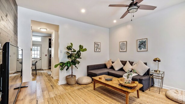 A modern living room with a sofa, coffee table, and a ceiling fan.