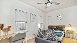 A modern bedroom with a bed, a desk, and a chair.