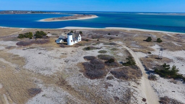 A white lighthouse on a sandy beach with a clear view of the ocean. - Chatham walk to Cape Cod beach  (Chatham)