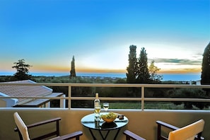 Enjoy a romantic dinner for two on this balcony overlooking a serene body of water and lush trees.