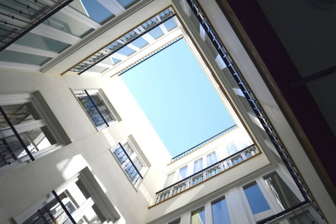 A multi-story building with balconies and large windows.
