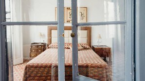 Ein Schlafzimmer mit Bett, Nachttischen und Wandbildern.