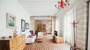 Ein Zimmer mit Schachbrettmuster-Boden, einem Holzkleiderschrank, einem Bett, einem Fernseher und einem Kleiderständer.