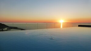 A sunset over a calm body of water with a clear sky. - Affittimoderni Castelsardo The Miramare (Castelsardo)