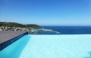 Piscina con vistas a un pueblo costero y al mar.