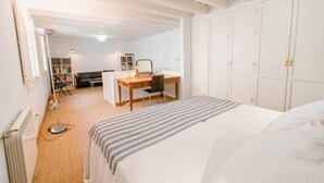 A bedroom with a bed, a desk, and a wardrobe. - Duplex de la Botanica - Cadiz (Cádiz)