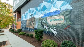 A mural on a building wall with the text "Welcome to GreenVille" and a cityscape.