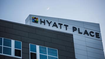 Fachada de un edificio con el letrero “HYATT PLACE” y un logotipo encima.