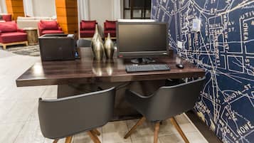 Un escritorio moderno de oficina con una computadora, dos sillas y jarrones decorativos.