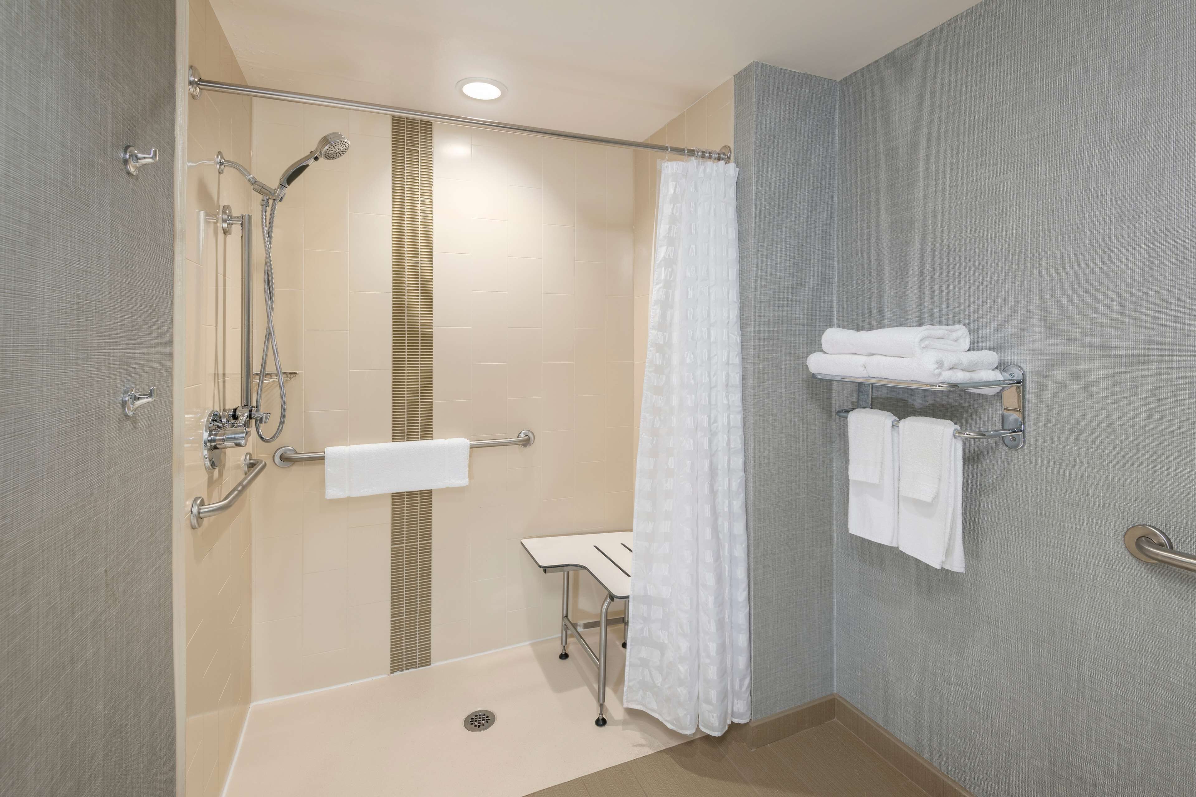 A modern bathroom with a shower, toilet, and sink.