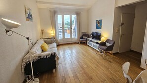 A compact room with a bed, a desk, two chairs, a TV, and a balcony with curtains. - 2 rooms with Big terrace of 25m ² in 350M of the Beach (ST MANDRIER SUR MER)