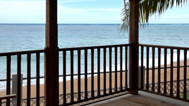 A wooden deck with a view of the ocean and beach. - Escape with the sound of the waves (Deshaies)