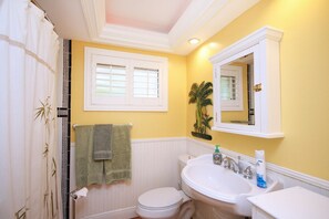 A bathroom with a toilet, sink, and shower curtain. -  Private tropical paradise 155 5 ⭐️ reviews. No cleaning, pet fees. Clothing opt. (Ft Myers)