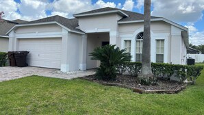 A residential house with a garage, a driveway, and a well-maintained lawn. - 4BD/3B,EXECUTIVE VILLA WITH SPA,MUST SEE,10 MIN FROM DISNEY (Kissimmee)