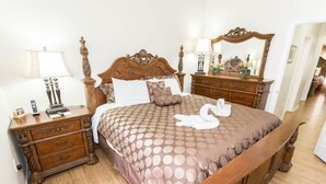 A neatly made bed with a patterned bedspread, wooden headboard, and matching nightstands with drawers. - 4BD/3B,EXECUTIVE VILLA WITH SPA,MUST SEE,10 MIN FROM DISNEY (Kissimmee)
