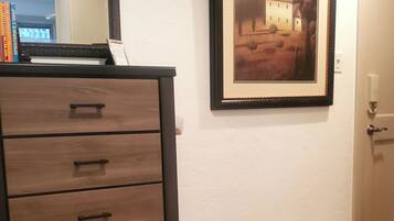 Una habitación con un aparador de madera, un cuadro en la pared y una puerta.