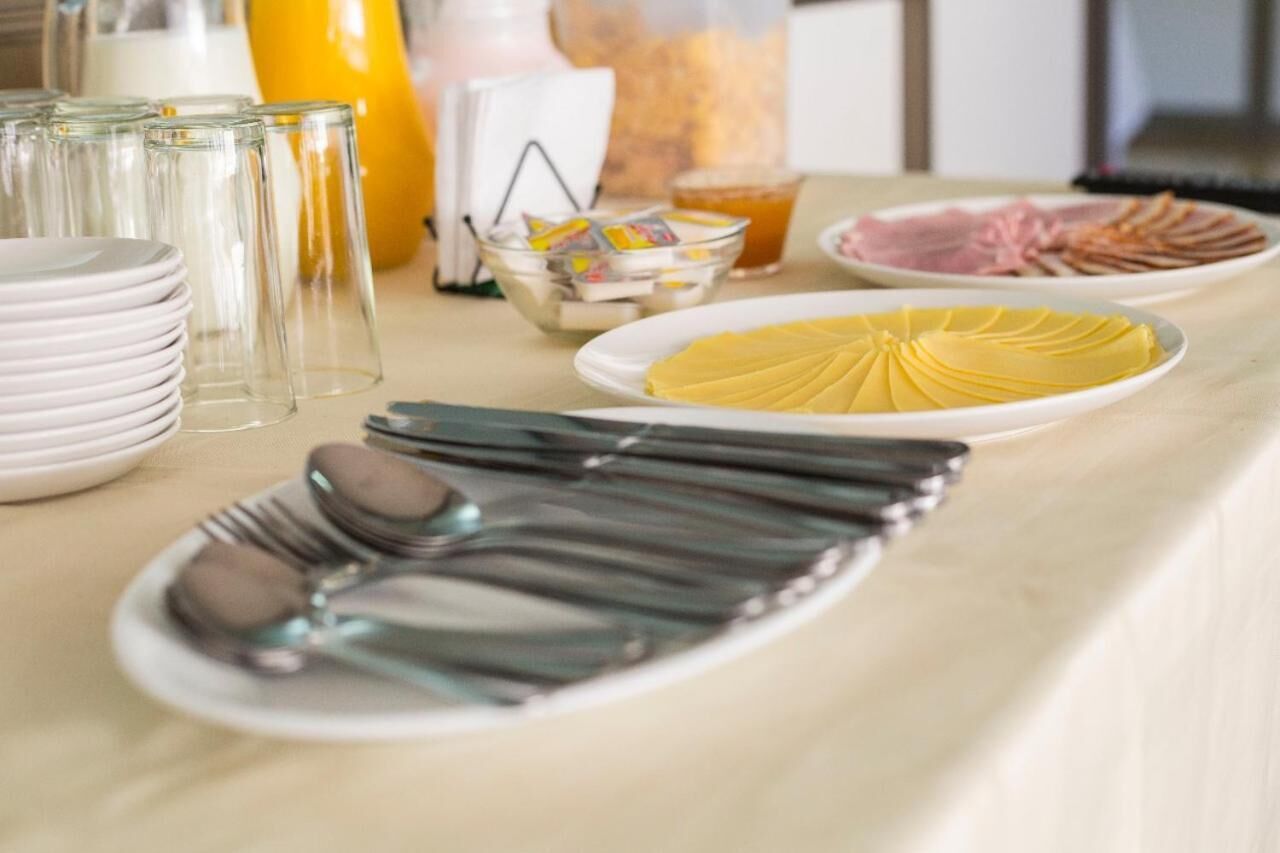 Montaje de bufé con platos de comida, vasos y cubiertos.
