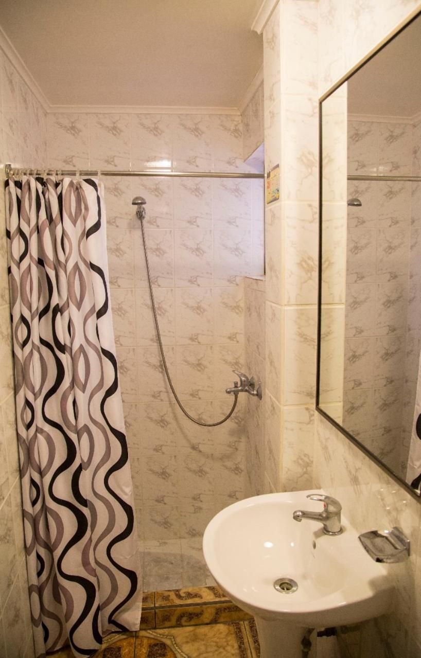 A bathroom with a shower, a sink, and a mirror.