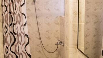 A bathroom with a shower, a sink, and a mirror.