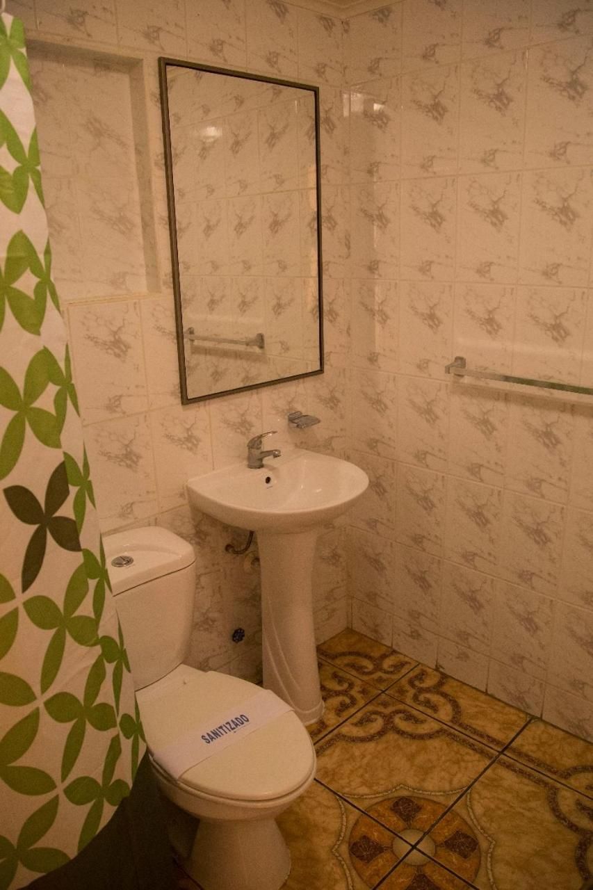 Un baño con inodoro, lavamanos y espejo.