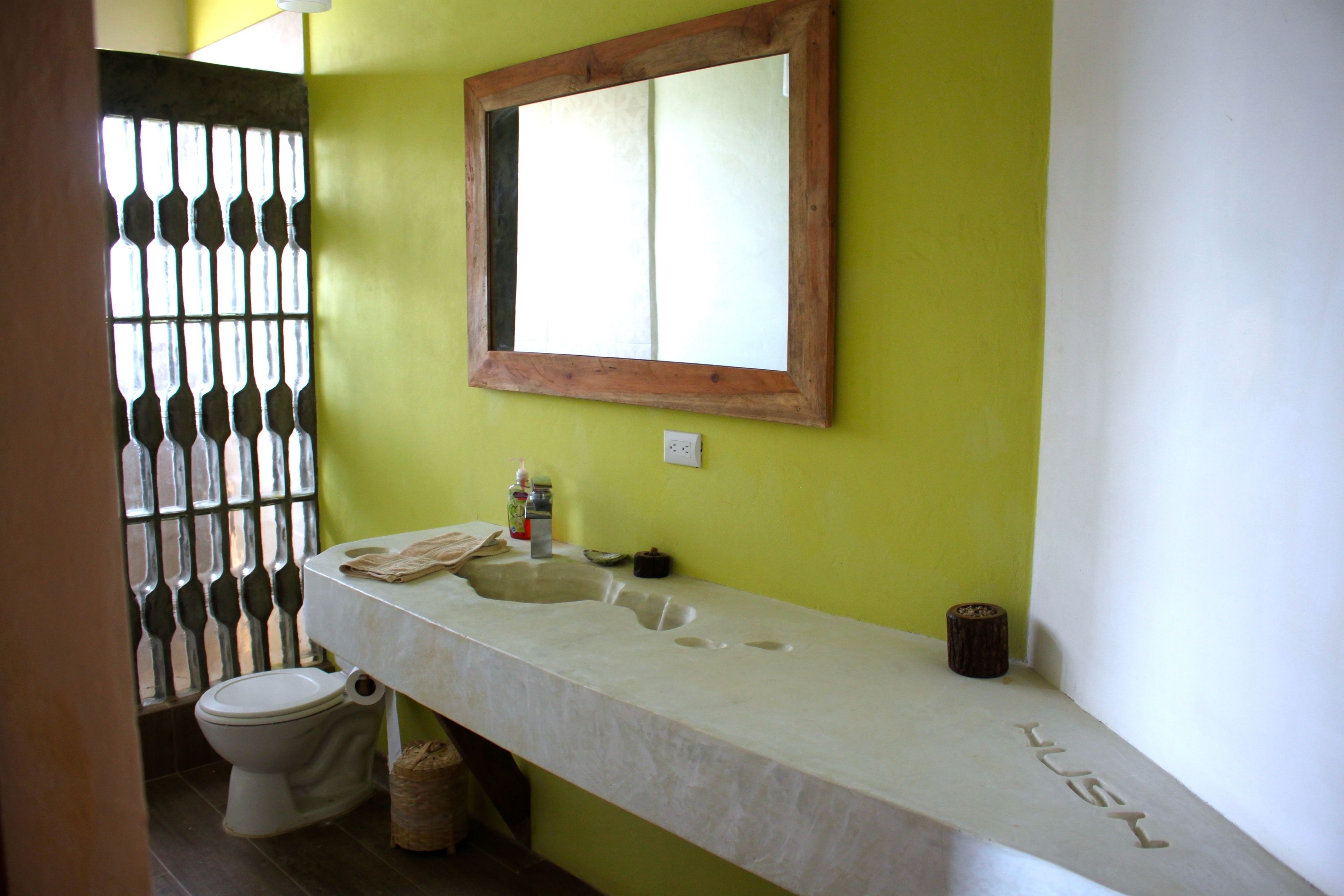 A bathroom with a white sink, a mirror, and a toilet.