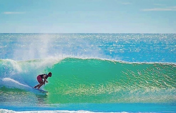 A surfer riding a wave in the ocean. - Hush Maderas (San Juan del Sur)