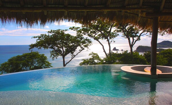 Una piscina al aire libre, sillones reclinables de piscina