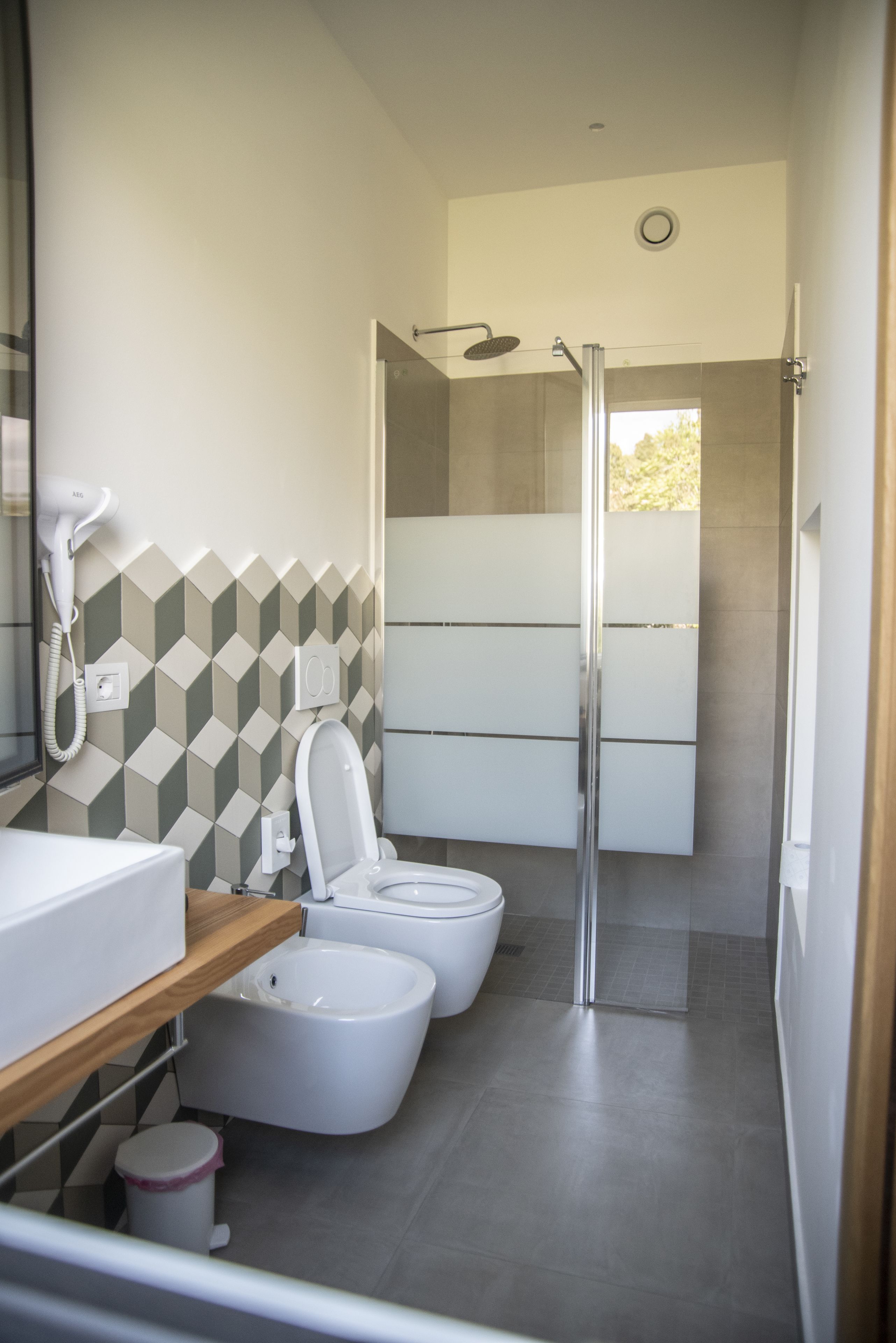 A modern bathroom with a shower, toilet, and bidet.