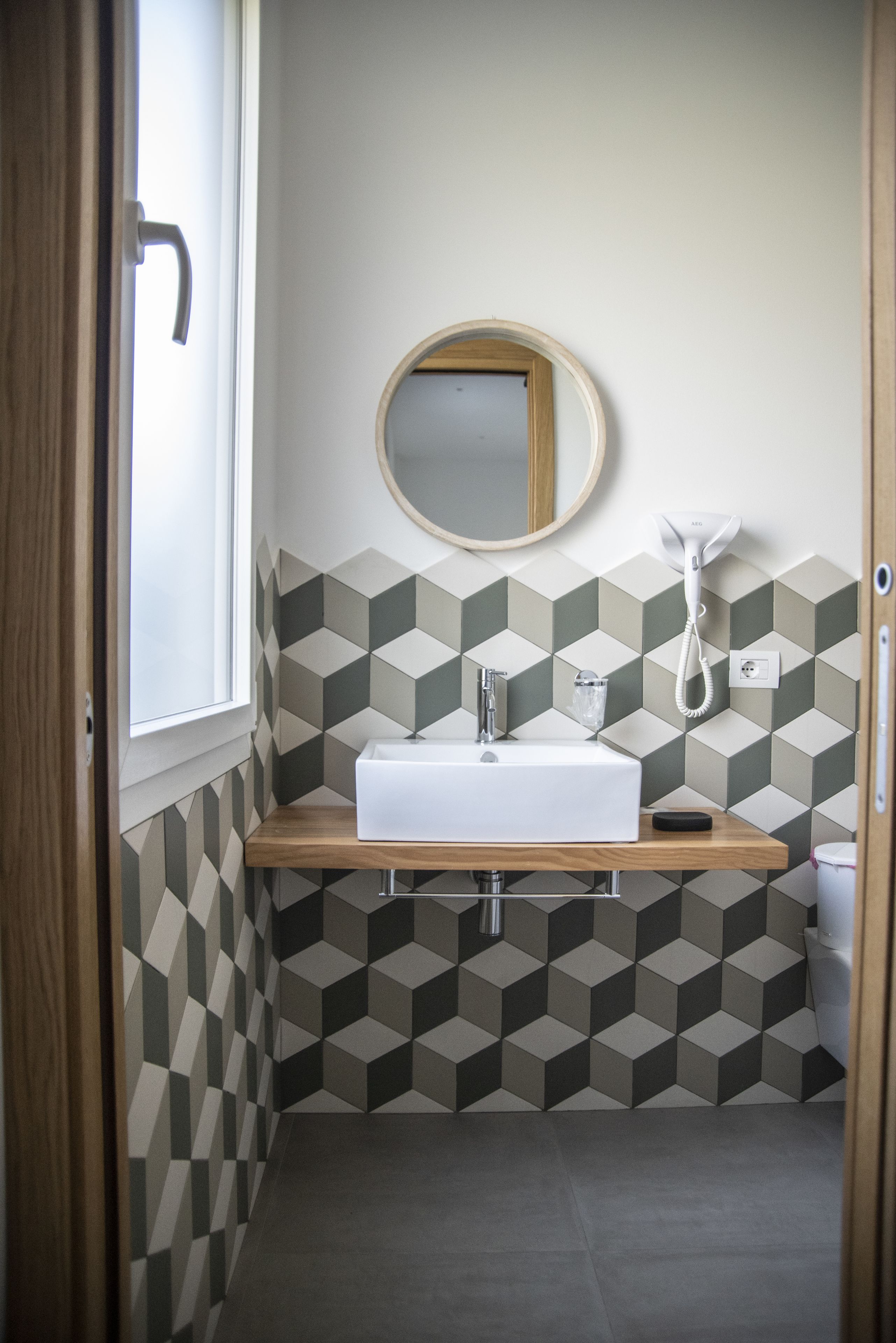 A bathroom with a white sink, a mirror, and a telephone.