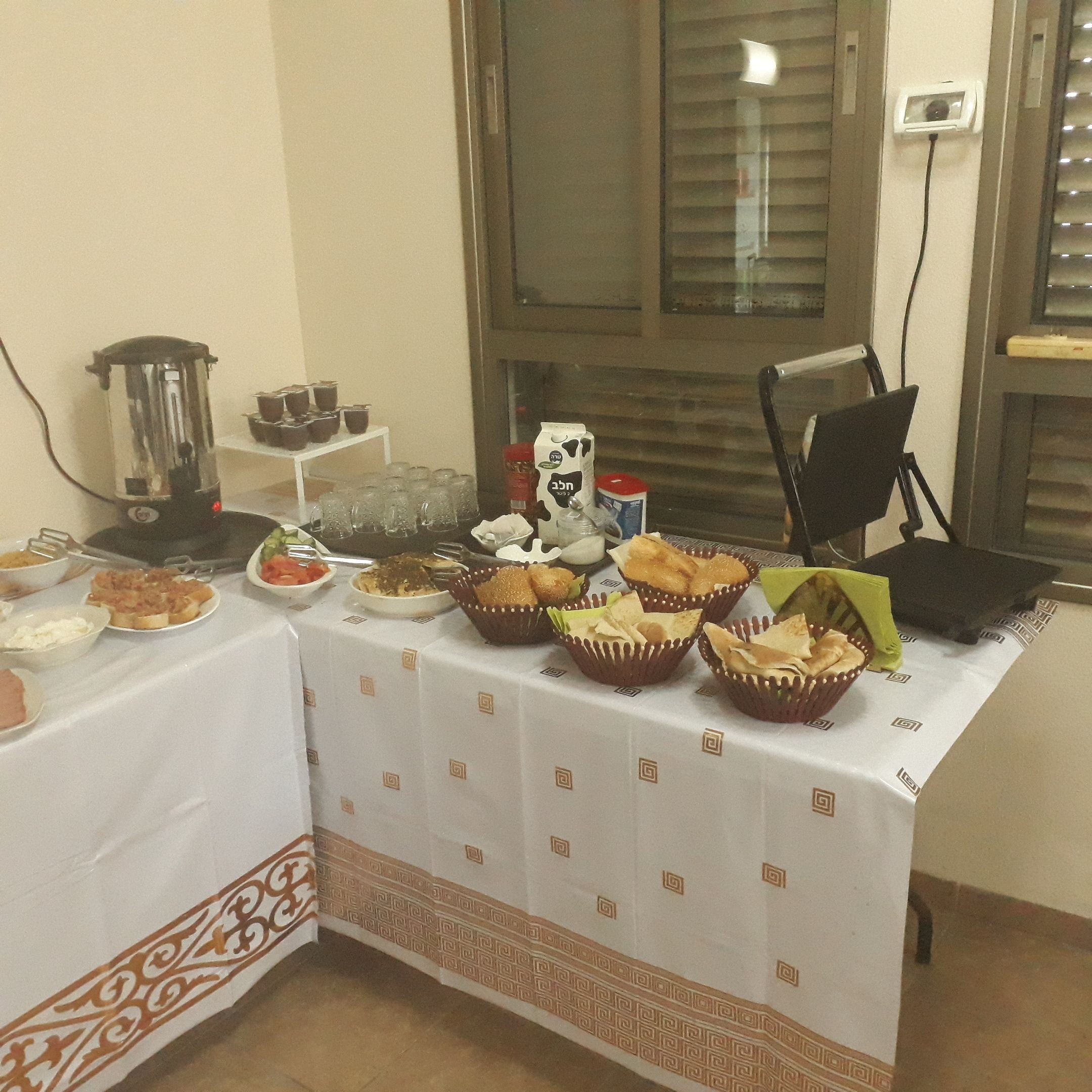Een buffet met diverse soorten eten en een koffieapparaat.