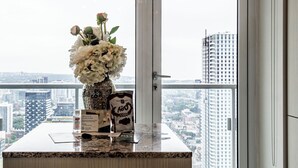 Ein Hotelrezeptionsschalter mit Blumen, einer Kaffeemaschine und einem Willkommensschild.