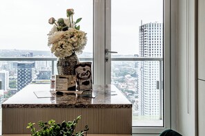 Een hotel receptiebalie met een bloemenvaas, een koffieapparaat en een bord met de leus welkom.